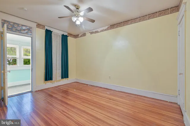 a view of an empty room with wooden floor