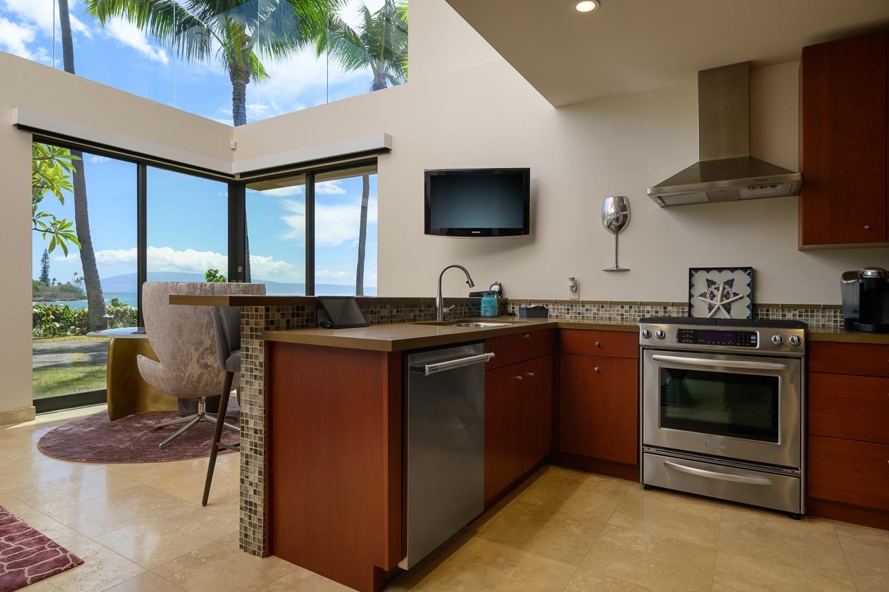 4809 Lower Honoapiilani Road Lahaina, HI 96761 - Photo 42 of 49 a kitchen with stainless steel appliances granite countertop a stove a sink and a microwave