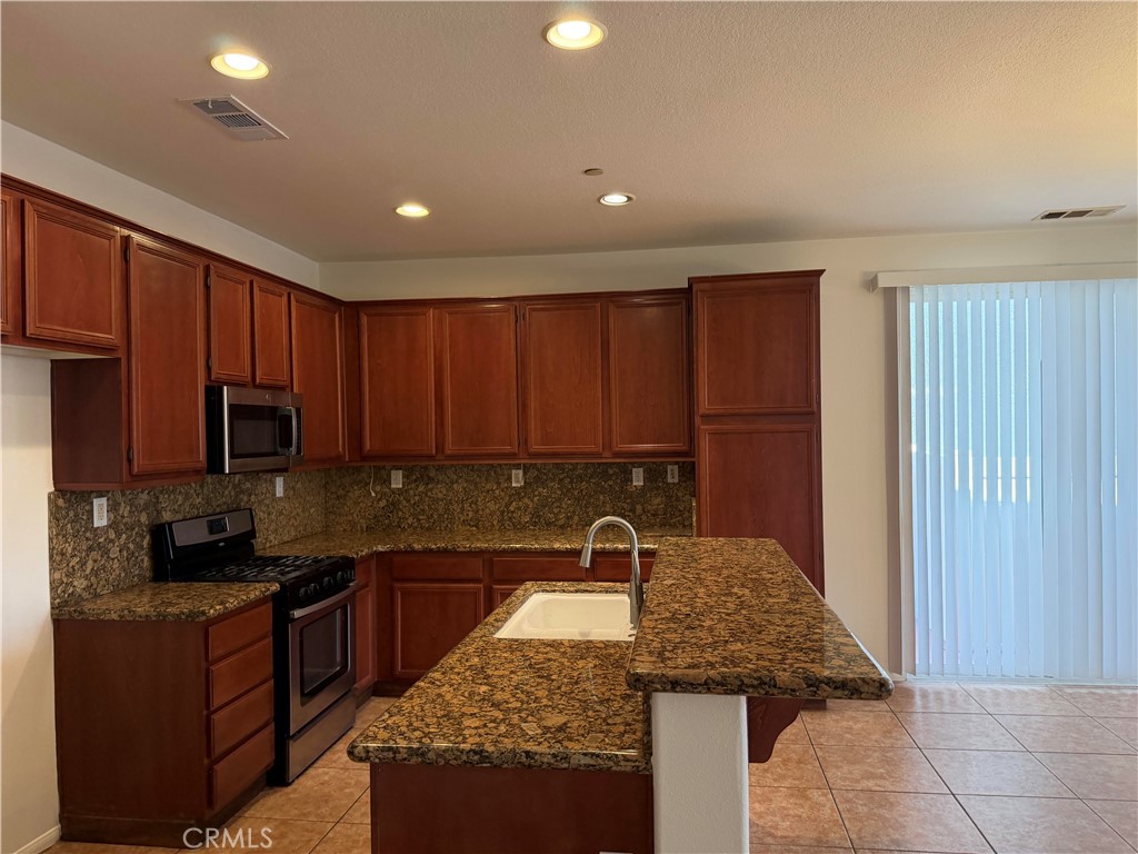 11012 Ragsdale Road Loma Linda, CA 92354 - Photo 6 of 27 a kitchen with a sink a stove cabinets and a wooden floor