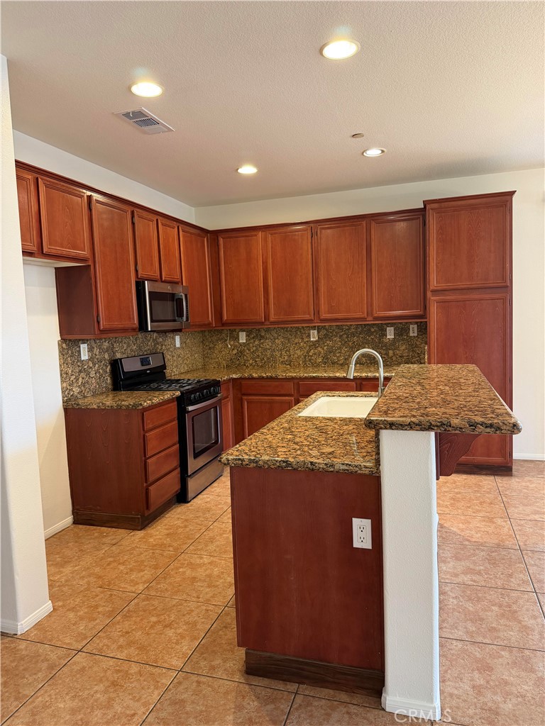 11012 Ragsdale Road Loma Linda, CA 92354 - Photo 7 of 27 a kitchen with stainless steel appliances granite countertop a stove a sink and a refrigerator