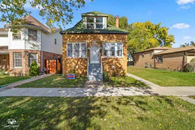a view of a house with brick walls and a yard with plants