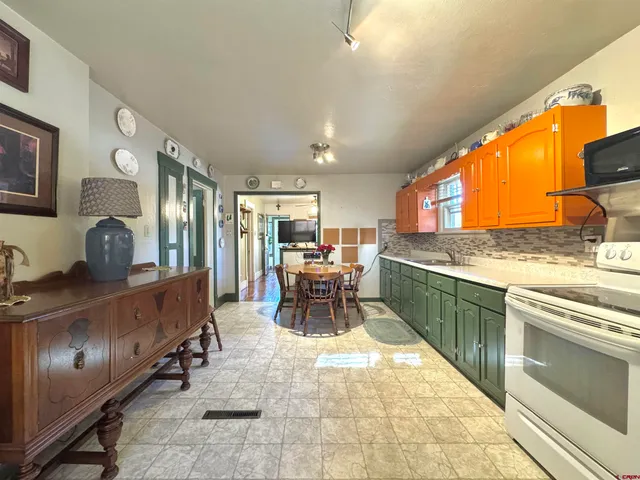 a large white kitchen with a large window and table