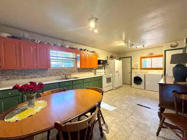 a kitchen with a table chairs refrigerator and microwave