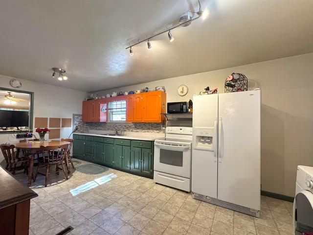 a kitchen with stainless steel appliances kitchen island granite countertop a refrigerator and a stove top oven