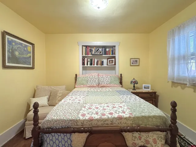 a bed sitting in a bedroom next to a window