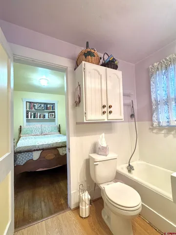 a bathroom with a granite countertop sink mirror vanity bathtub and toilet