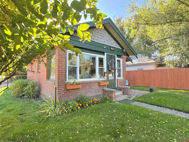 a backyard of a house with table and chairs