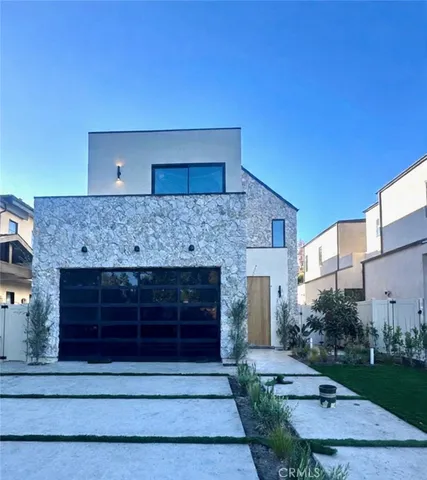 a front view of a house with a garden