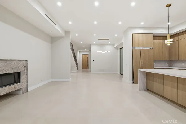 a large kitchen with stainless steel appliances granite countertop a sink and a refrigerator