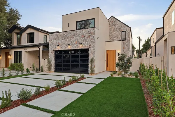 a front view of a house with a garden