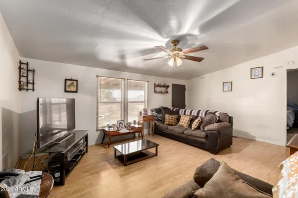 a living room with furniture a flat screen tv and a large window
