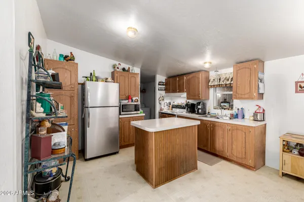 a kitchen with a refrigerator a stove top oven a sink and cabinets