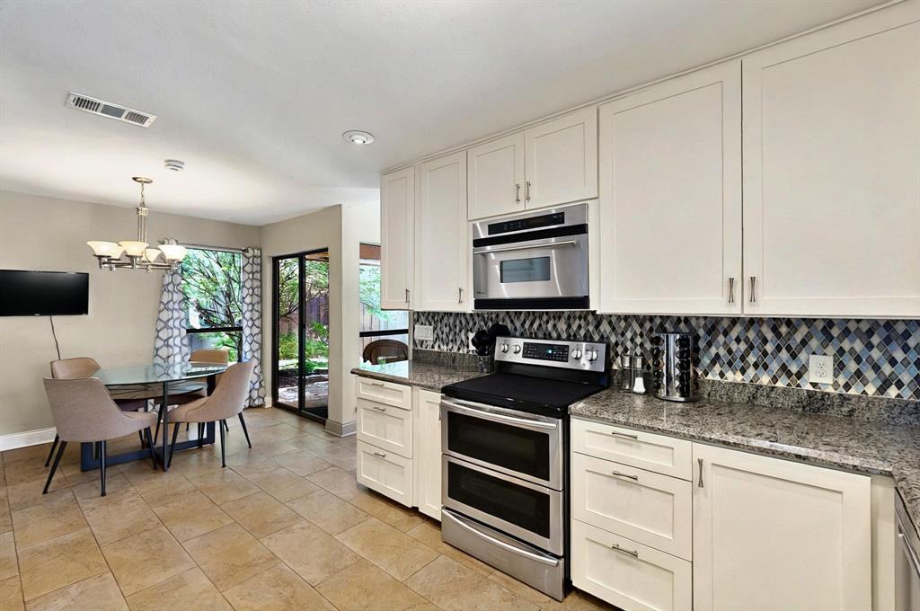 7109 Alpha Road Dallas, TX 75240 - Photo 14 of 36 a kitchen with granite countertop a sink cabinets and stainless steel appliances