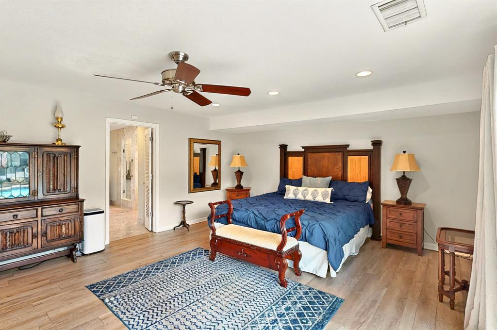 7109 Alpha Road Dallas, TX 75240 - Photo 26 of 36 a bedroom with a bed and wooden floor