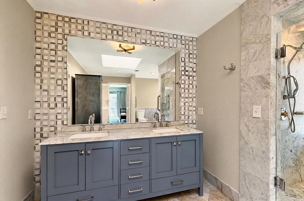 7109 Alpha Road Dallas, TX 75240 - Photo 29 of 36 a bathroom with a double vanity sink and a mirror