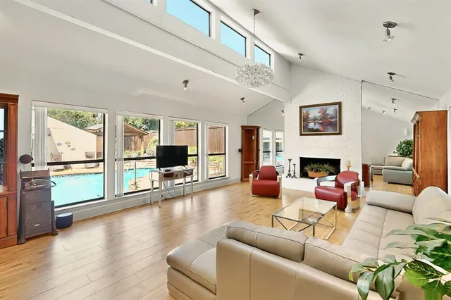 a living room with furniture fireplace and a large window