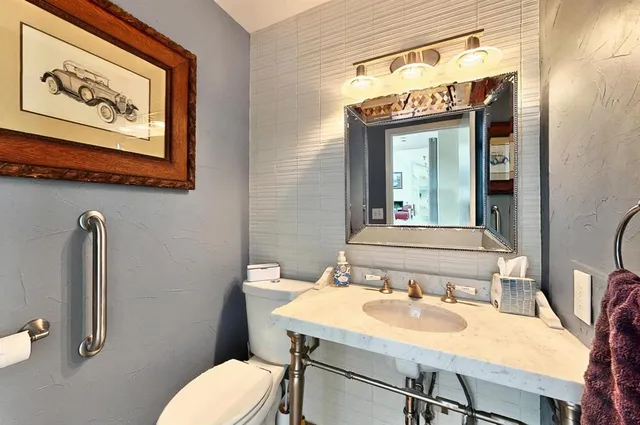 a bathroom with a toilet sink and mirror