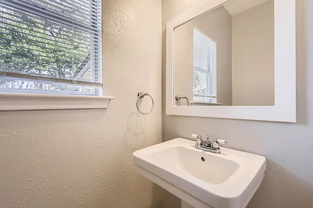 a bathroom with a sink a mirror and a window