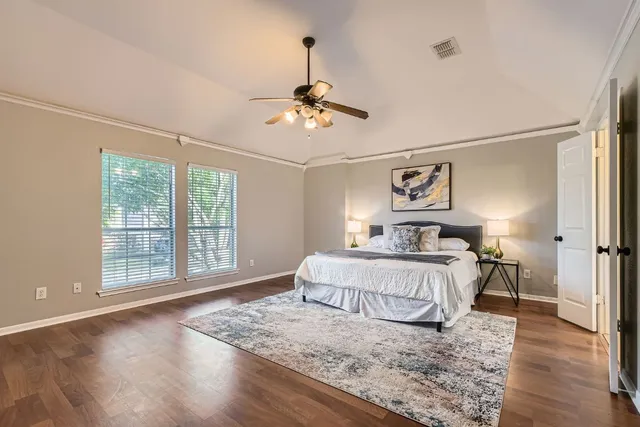 a living room with a bed furniture and wooden floor