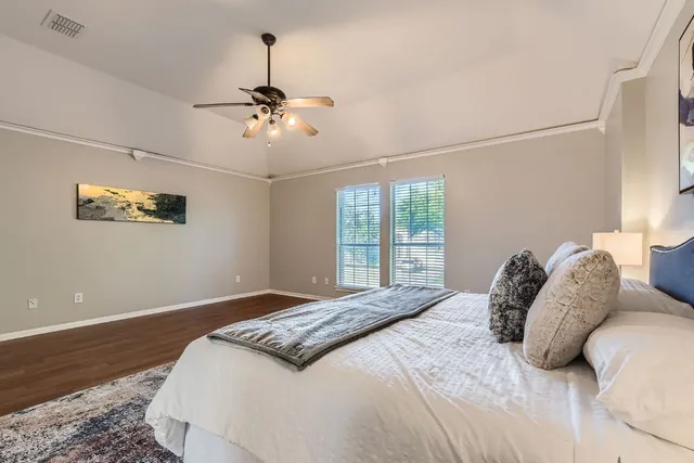a bedroom with a bed ceiling fan and a window