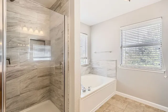 a bathroom with a tub shower and sink