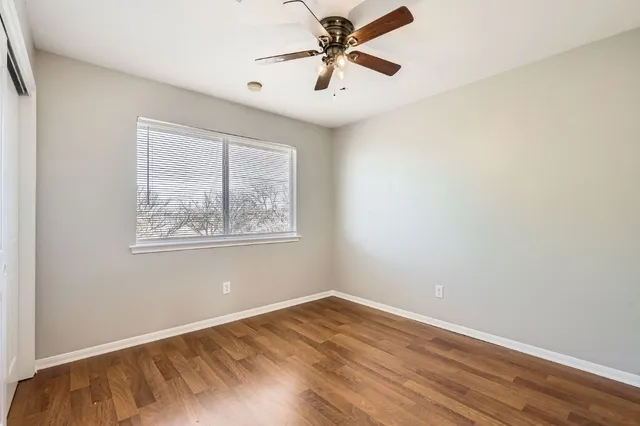 an empty room with a window and a fan