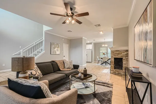 a living room with furniture a fireplace and a chandelier