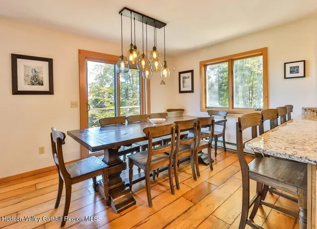 a view of a dining room with furniture a chandelier and wooden floor