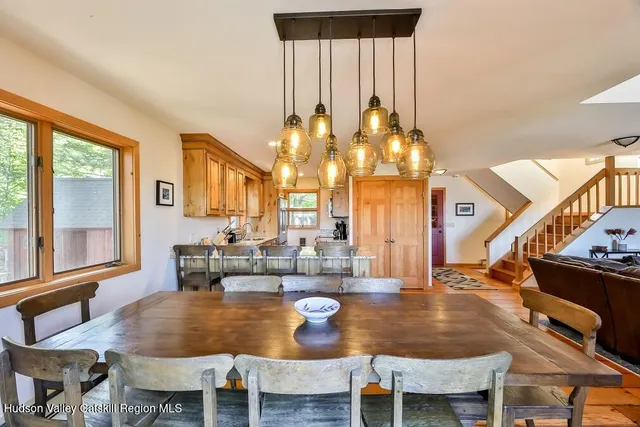 a dining room with wooden floor a glass table and chairs