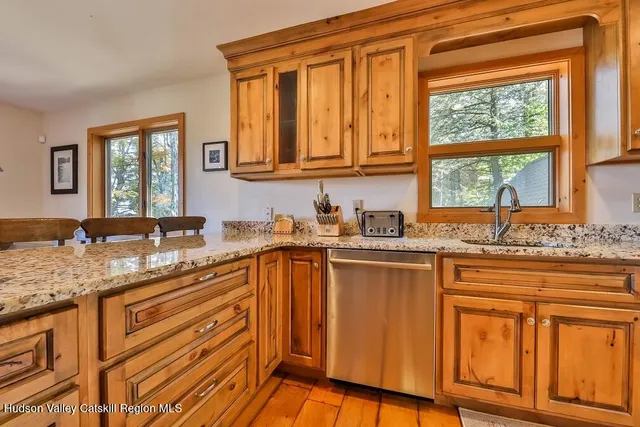 a kitchen with stainless steel appliances granite countertop wooden cabinets a sink and a stove