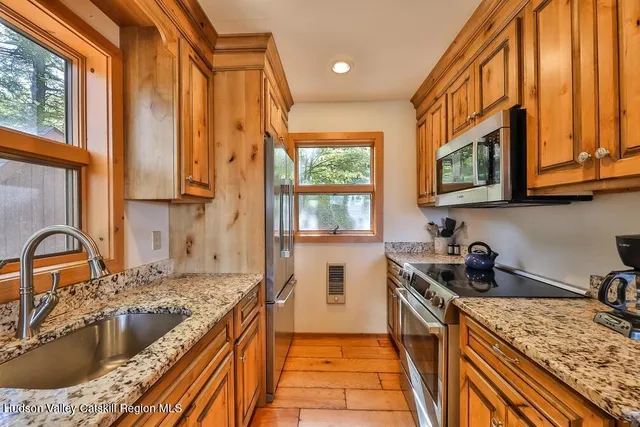 a bedroom with a bed and a dresser next to a window