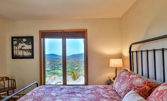 a bedroom with a bed and a large window
