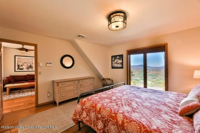 a bedroom with a bed and a lamp next to a window