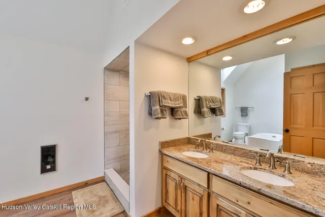 a en suite bathroom with a granite countertop sink and a mirror