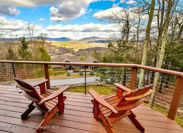 a view of a balcony with wooden chairs
