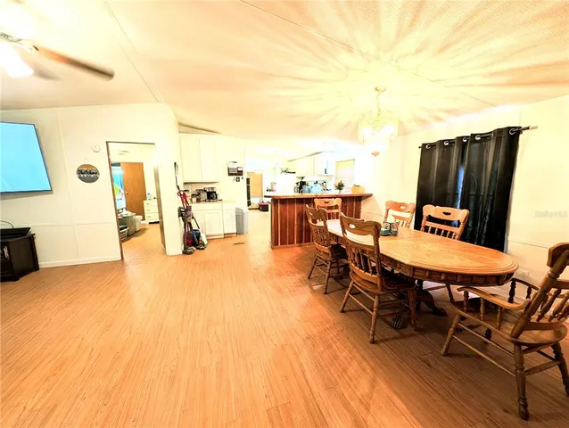 a kitchen with stainless steel appliances a kitchen island hardwood floor sink stove and wooden cabinets