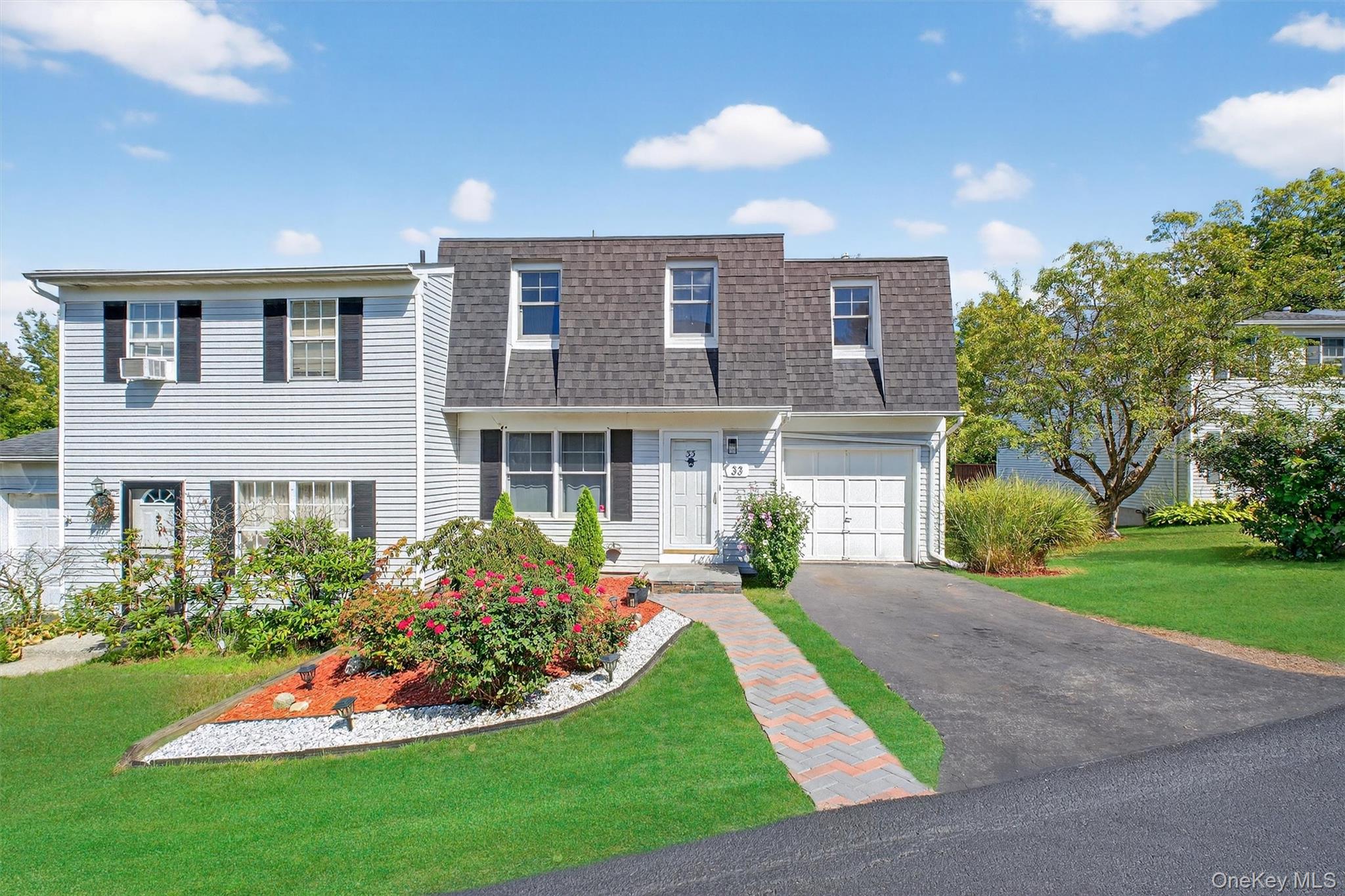a front view of a house with a yard and potted plants