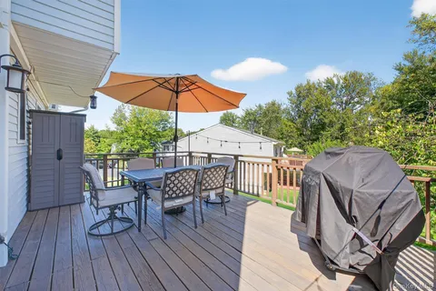 a view of deck with table and chairs under an umbrella with wooden floor