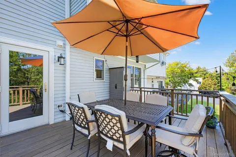 a wooden deck with a table and chairs under an umbrella