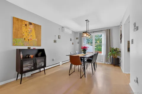 a dining room with furniture potted plants and wooden floor