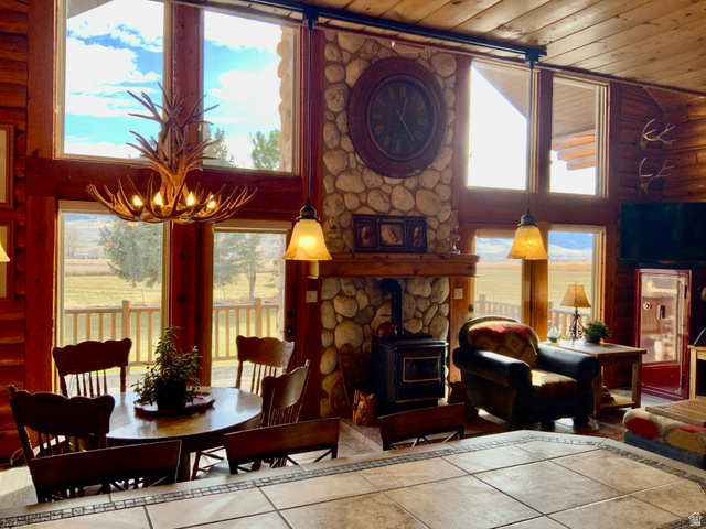 76 Highway 118 Monroe, UT 84754 - Photo 24 of 76 Tiled dining room with a wood stove, a towering ceiling, and wooden ceiling