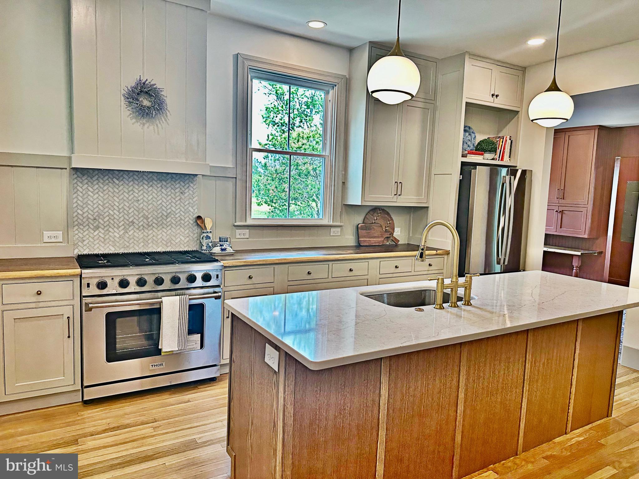 3860 Main Street Trappe, MD 21673 - Photo 19 of 58 a kitchen with stainless steel appliances granite countertop a sink a stove and a refrigerator