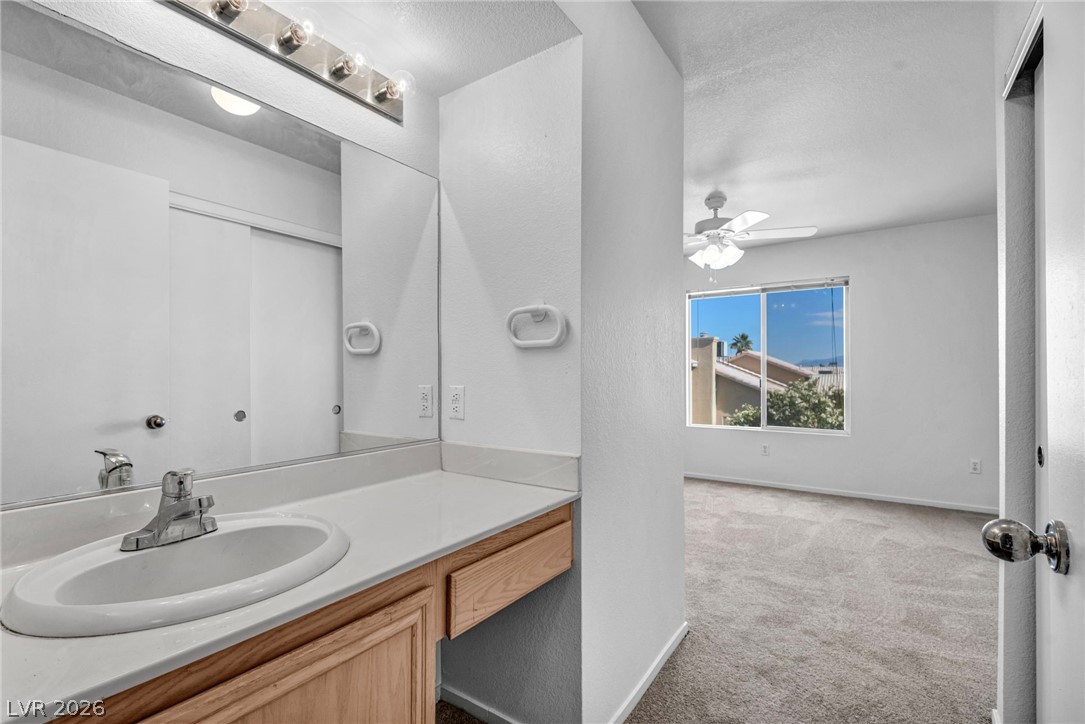 8070 West Russell Road, Unit 2060 Las Vegas, NV 89113 - Photo 15 of 47 Bright and airy bedroom features a functional vanity area and soft carpeting.