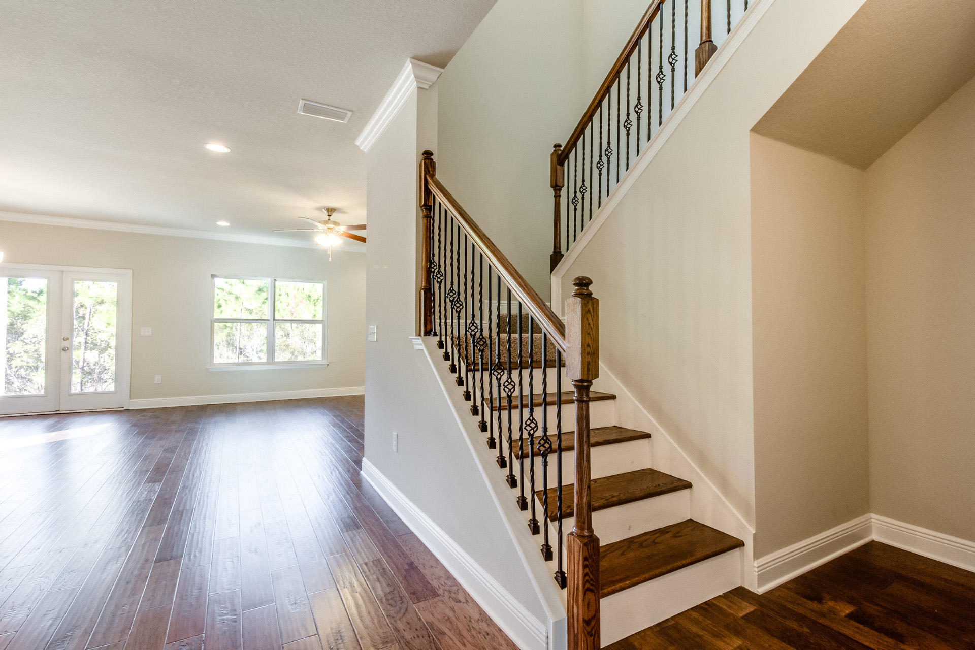 a view of staircase with wooden floor and white walls