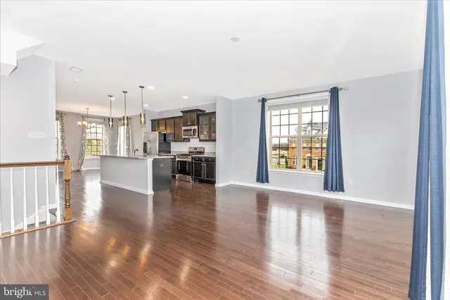 a view of a big room with wooden floor and windows