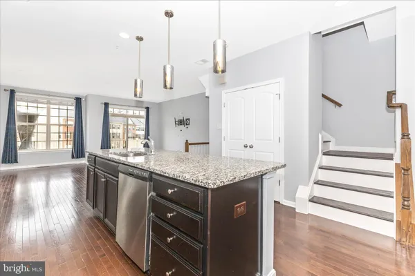 a kitchen with granite countertop a sink a counter space and stainless steel appliances