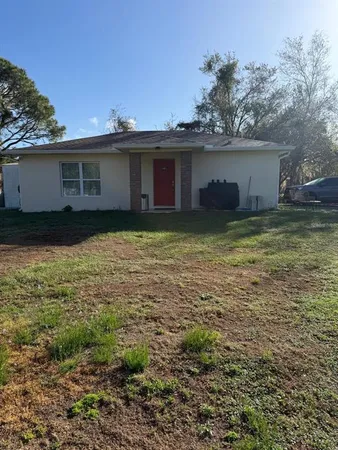 a view of a house with a large window and a yard