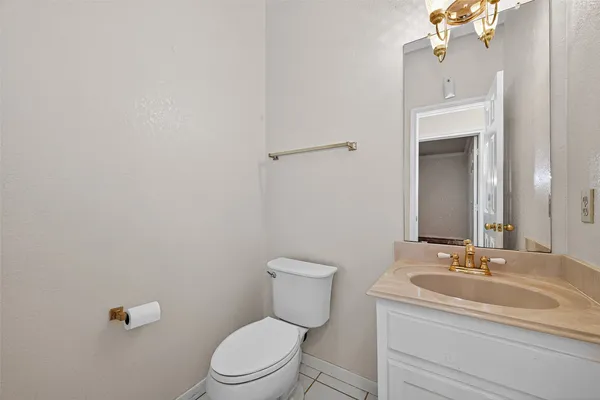 a bathroom with a granite countertop toilet a sink and mirror