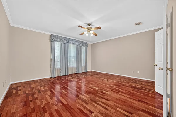 a view of a big room with wooden floor and a chandelier fan