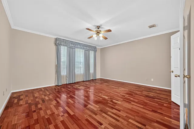 a view of a big room with wooden floor and a chandelier fan